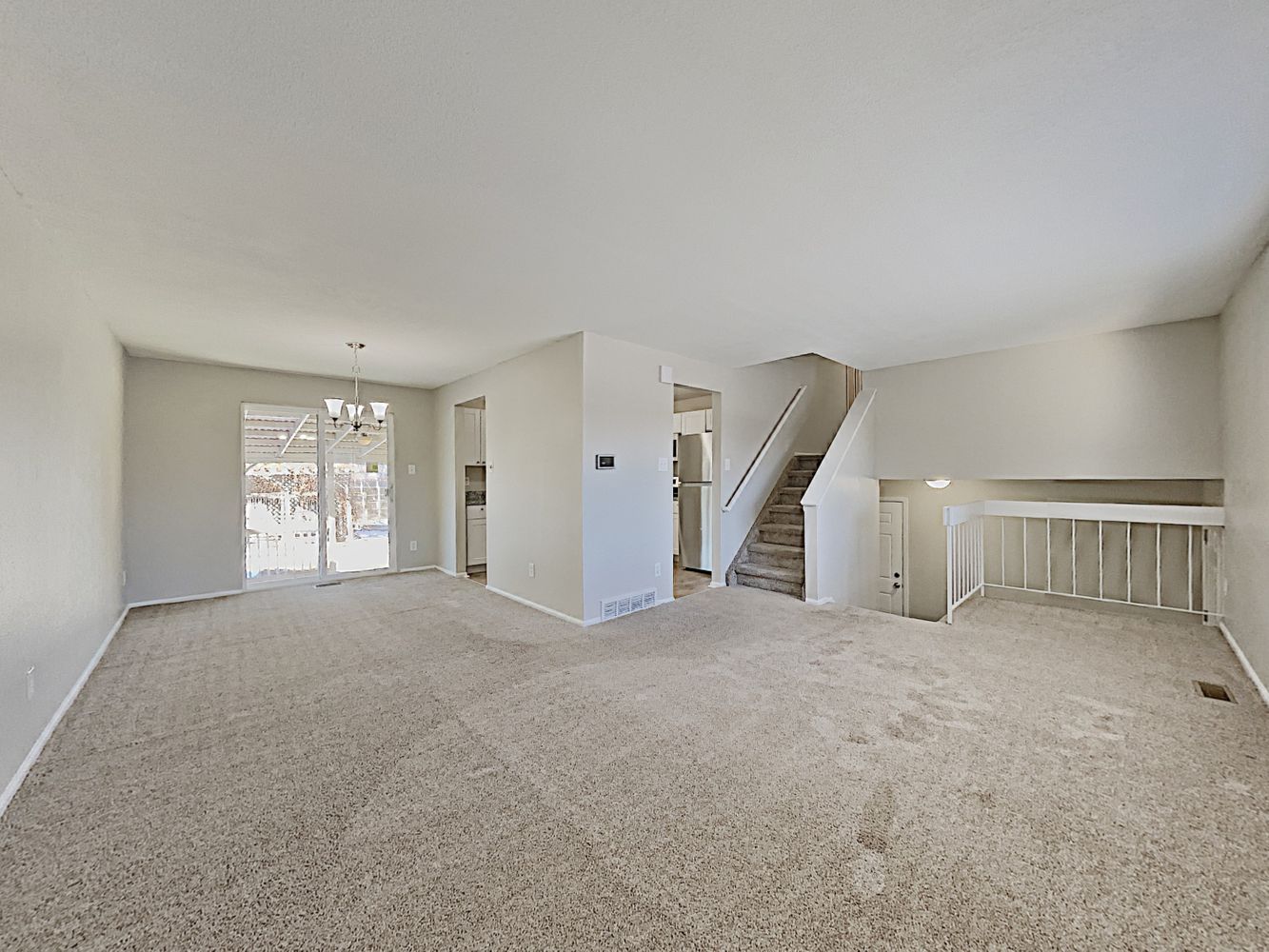 Large carpeted living space in split-level home at Invitation Homes Denver.