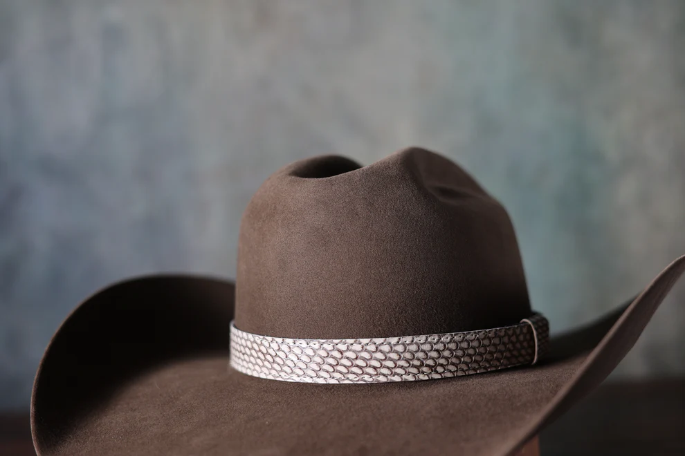 Add an exotic and premium edge to your favorite hat. These 1-inch wide hat bands feature genuine, patterned Python and Cobra snake skin. Unlike traditional bands, it uses a simple Velcro binding and a snake skin keeper for a secure, sleek finish. The design is fully adjustable, making it easy to size and transfer between hats.