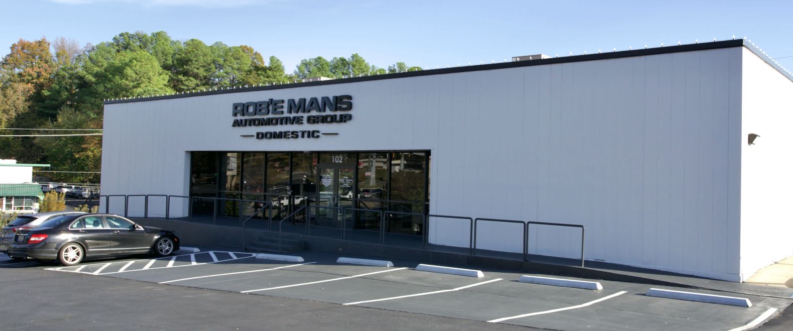 Side exterior view of Rob’e Mans Domestic Auto Repair, a family-owned automotive repair and maintenance facility serving Homewood, Birmingham, and surrounding Central Alabama communities since 1983. The building features professional automotive branding, multiple service bay areas, and a clean industrial-style exterior designed to support high-quality Domestic and American-made vehicle repair services. Rob’e Mans Domestic Auto Repair specializes in Ford, Chevrolet, GMC, Dodge, RAM, Jeep, Chrysler, Cadillac, and Buick repair including engine diagnostics, brake repair, transmission service, suspension repair, oil changes, tire services, and preventive maintenance performed by ASE-certified technicians.