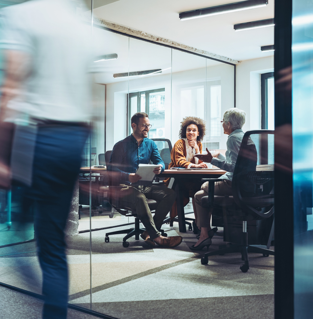 An advisor meeting with a client couple to review documents in their boardroom.