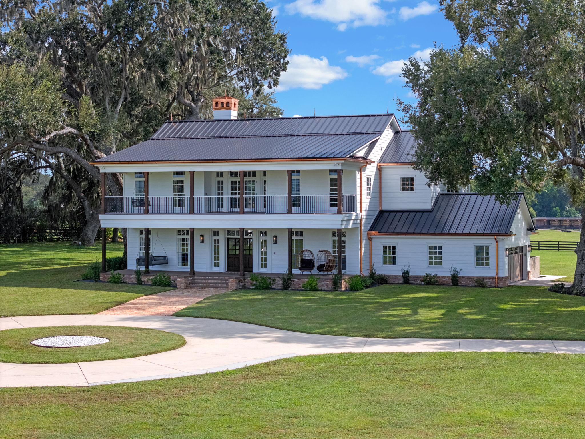 Custom luxury home in Central Florida featuring modern farmhouse architecture and a standing seam metal roof, showcasing the craftsmanship of custom home builders in Central Florida.