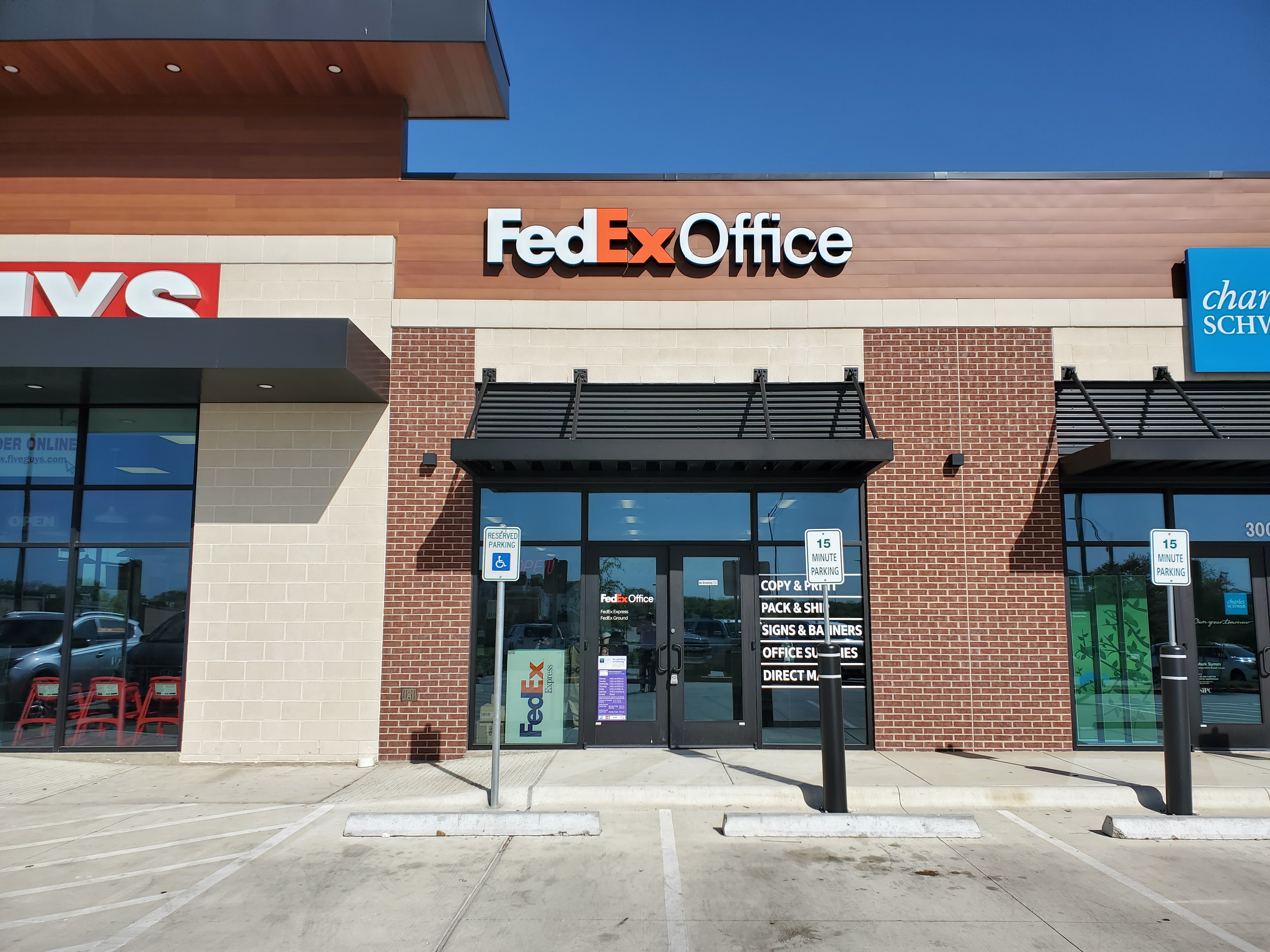 Exterior of FedEx Office Print and Ship Center in College Station Texas with storefront signage, customer entrance, and parking for shipping and printing services.