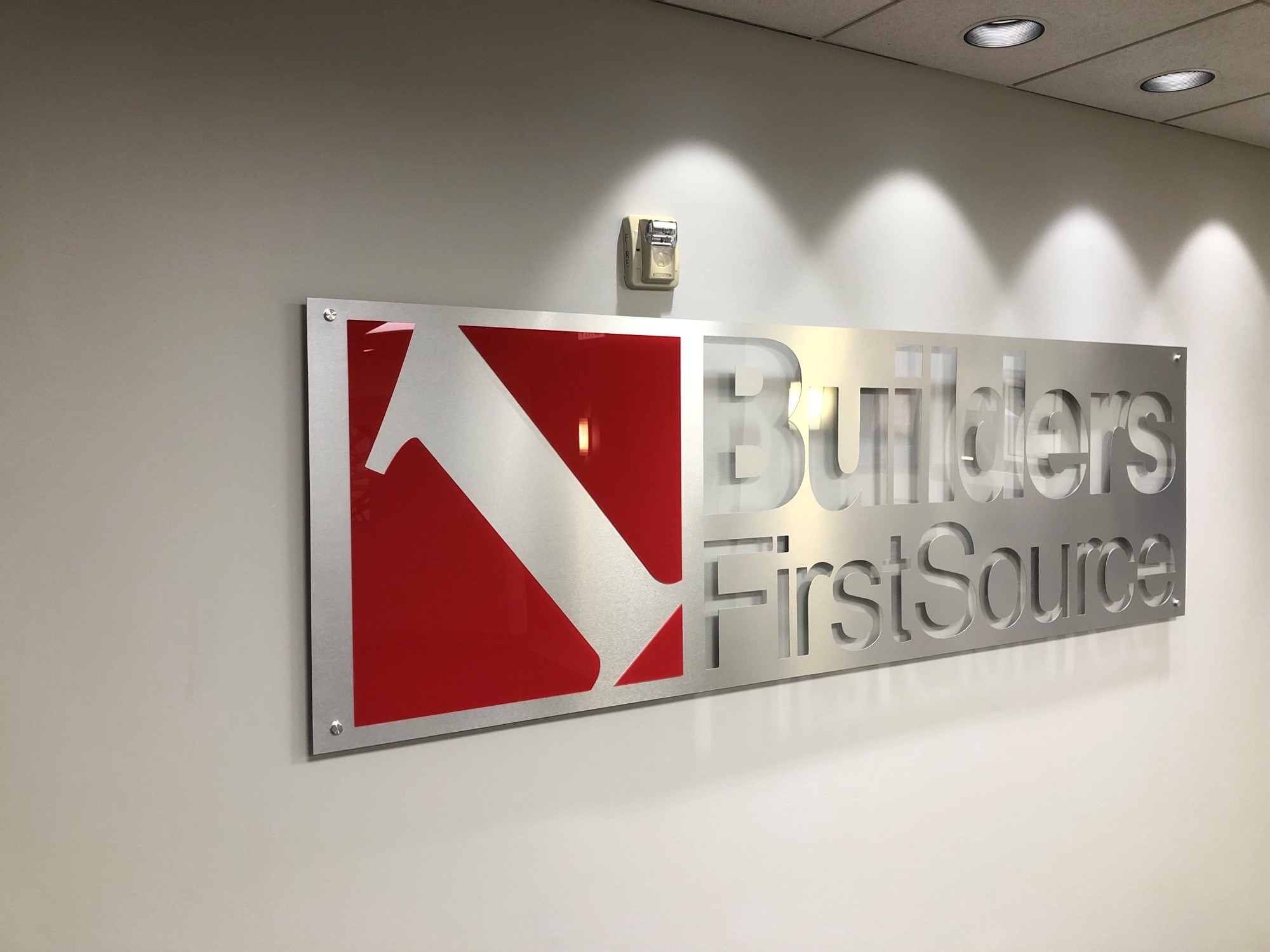 Builders FirstSource building materials metal logo sign on wall.