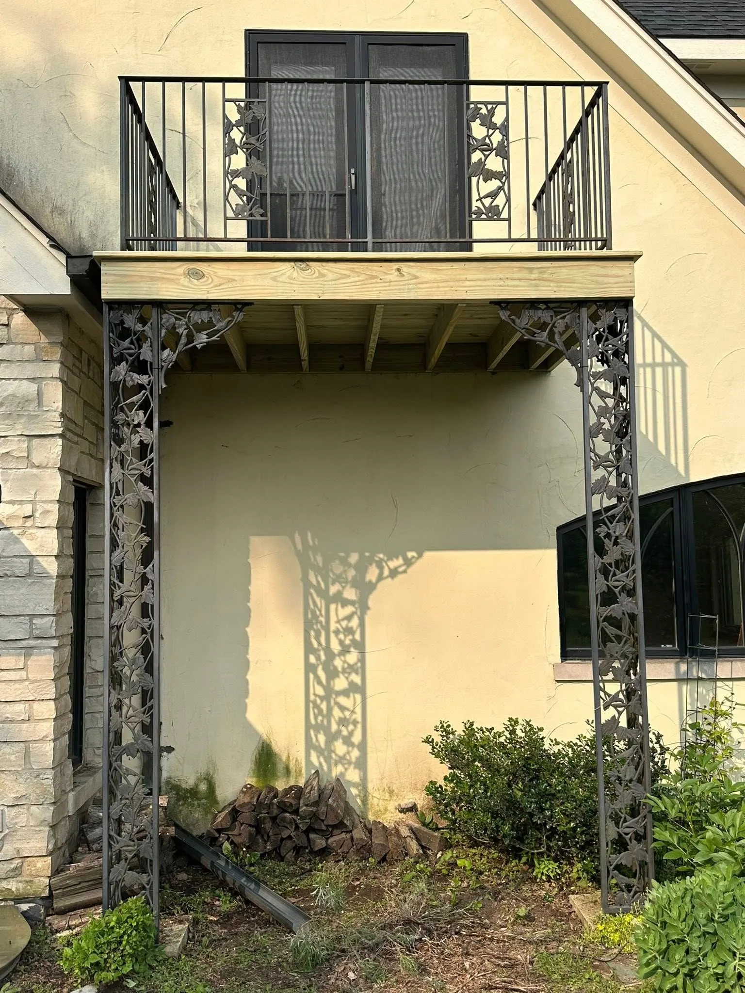 Custom decorative metal balcony with ornamental support columns enhances this home's exterior, combining structural strength, elegant craftsmanship, durable materials, modern design, and long-lasting curb appeal for residential properties.