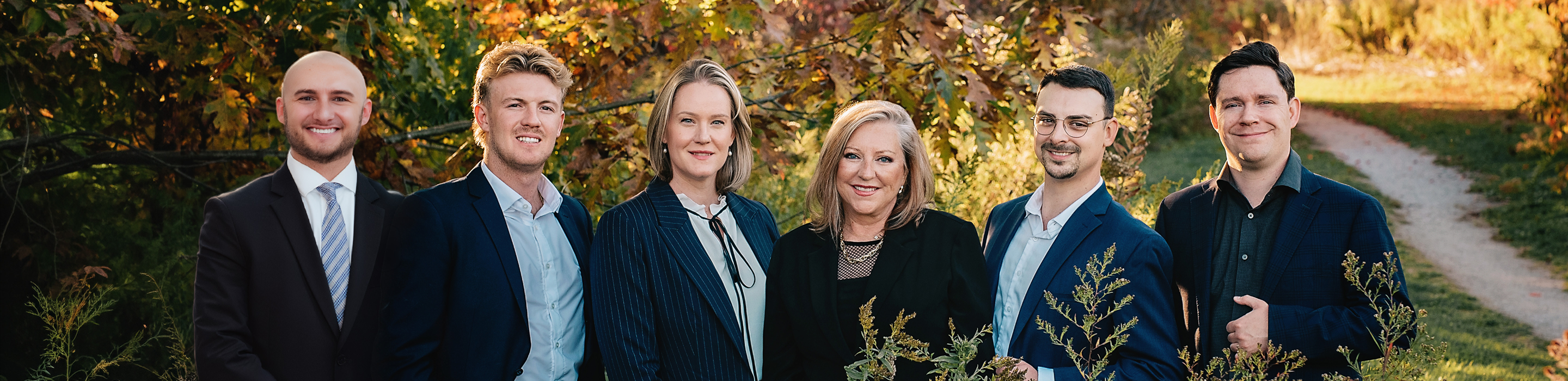The Brenda Miller Family Wealth team posed outside among the multi-coloured autumn trees.