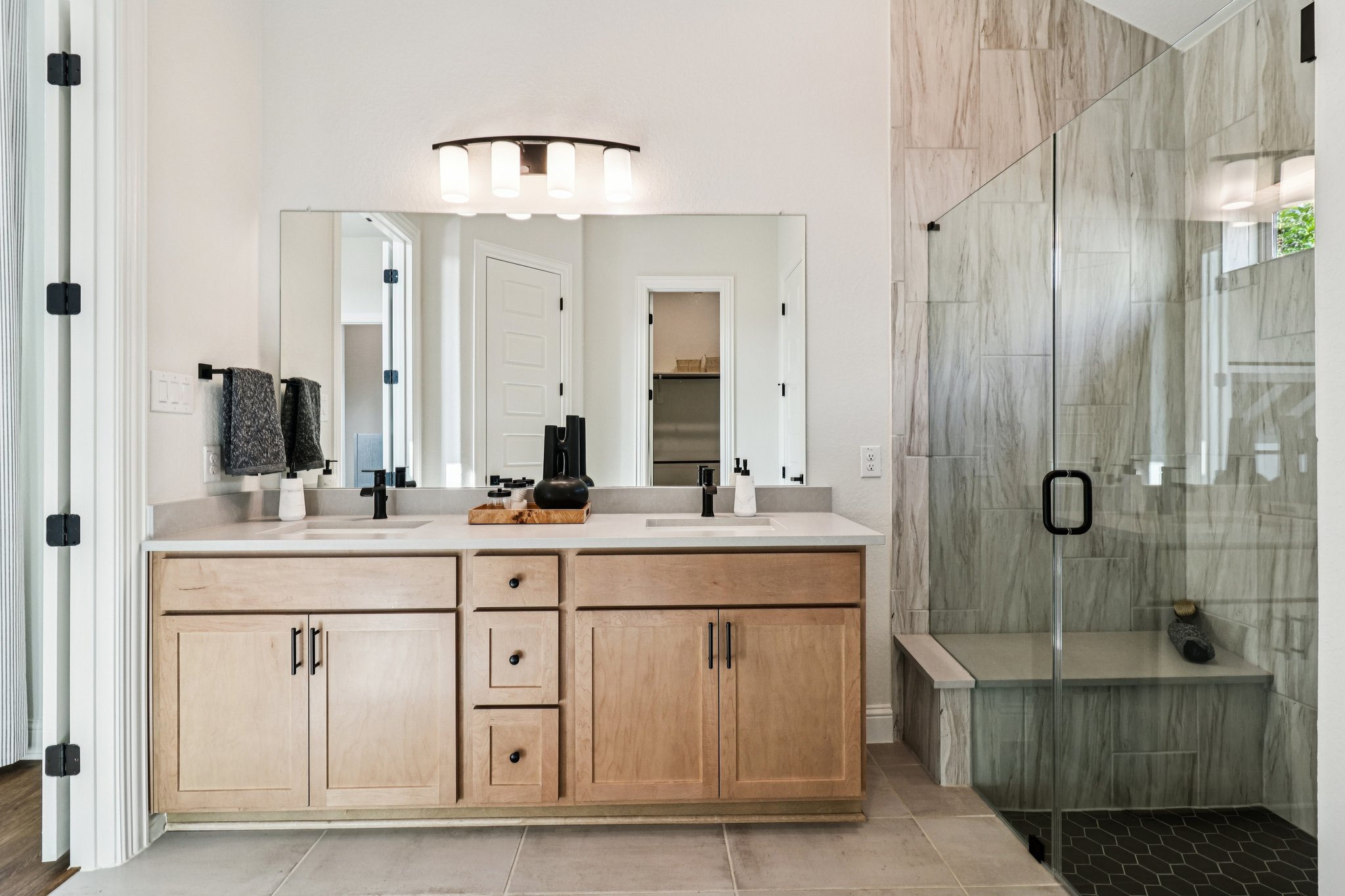 Dual Vanity including an Expansive Shower with Shower Seat 