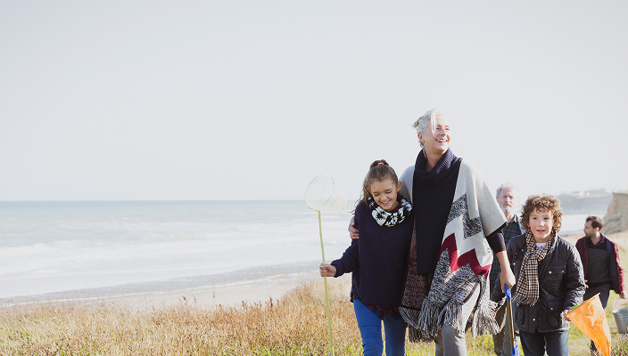 A multigenerational family out for a walk together near a beach.