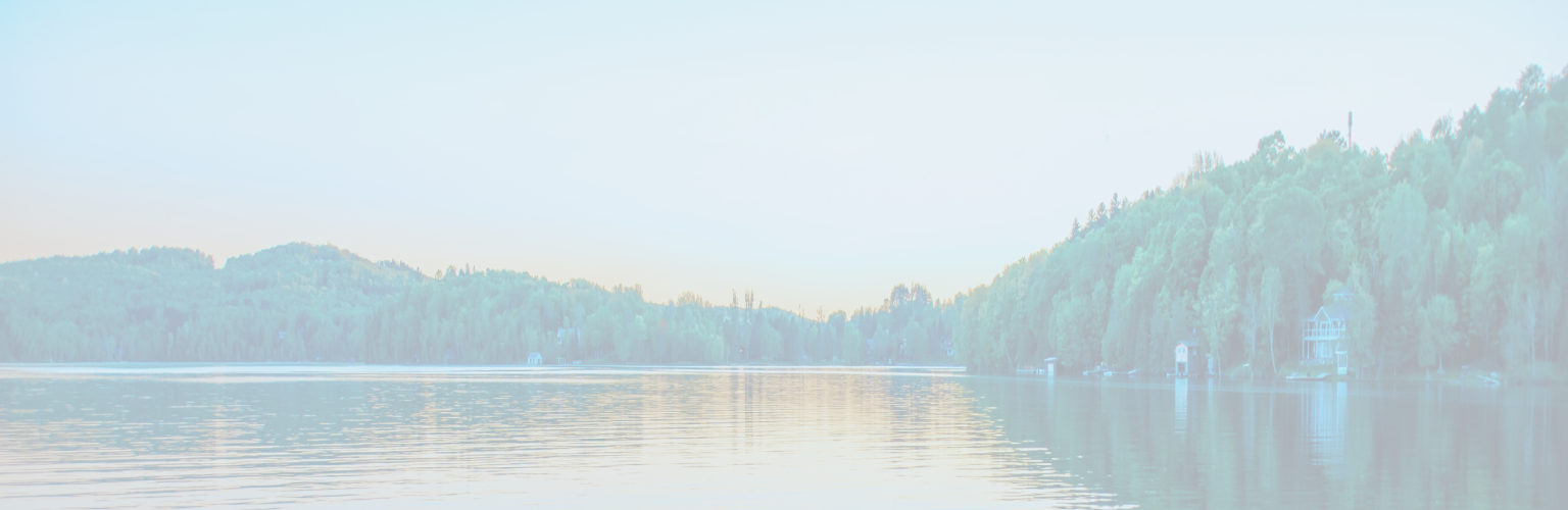 A lake surrounded by trees at sunset.