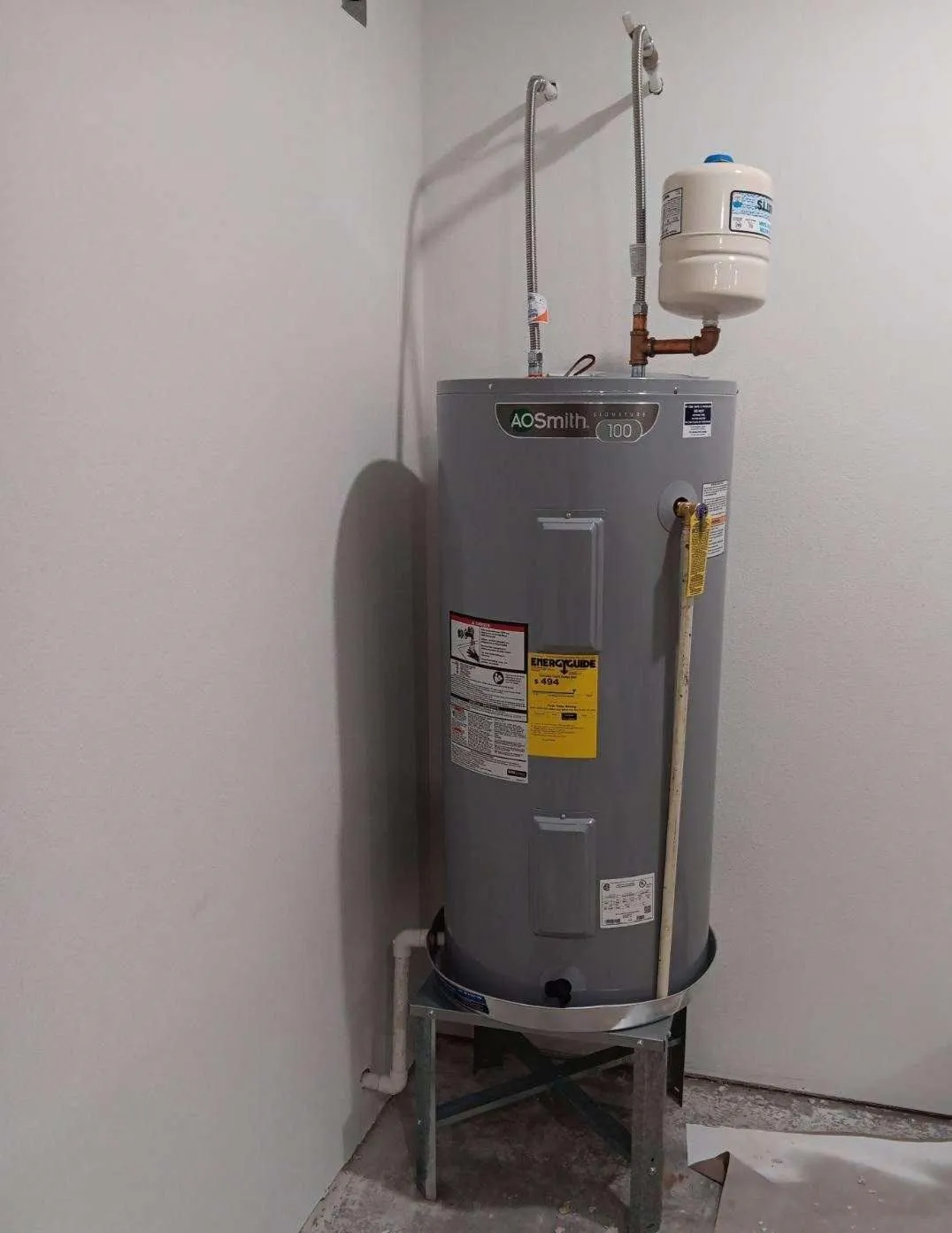 AO Smith residential storage water heater professionally installed with expansion tank and plumbing connections, ensuring reliable hot water supply, safety compliance, energy efficiency, and dependable home comfort throughout every season.