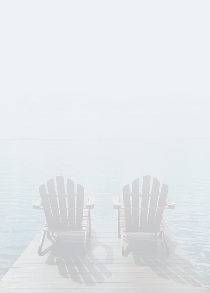 Deux chaises Muskoka sur un quai face à un lac, par une journée partiellement ensoleillée.