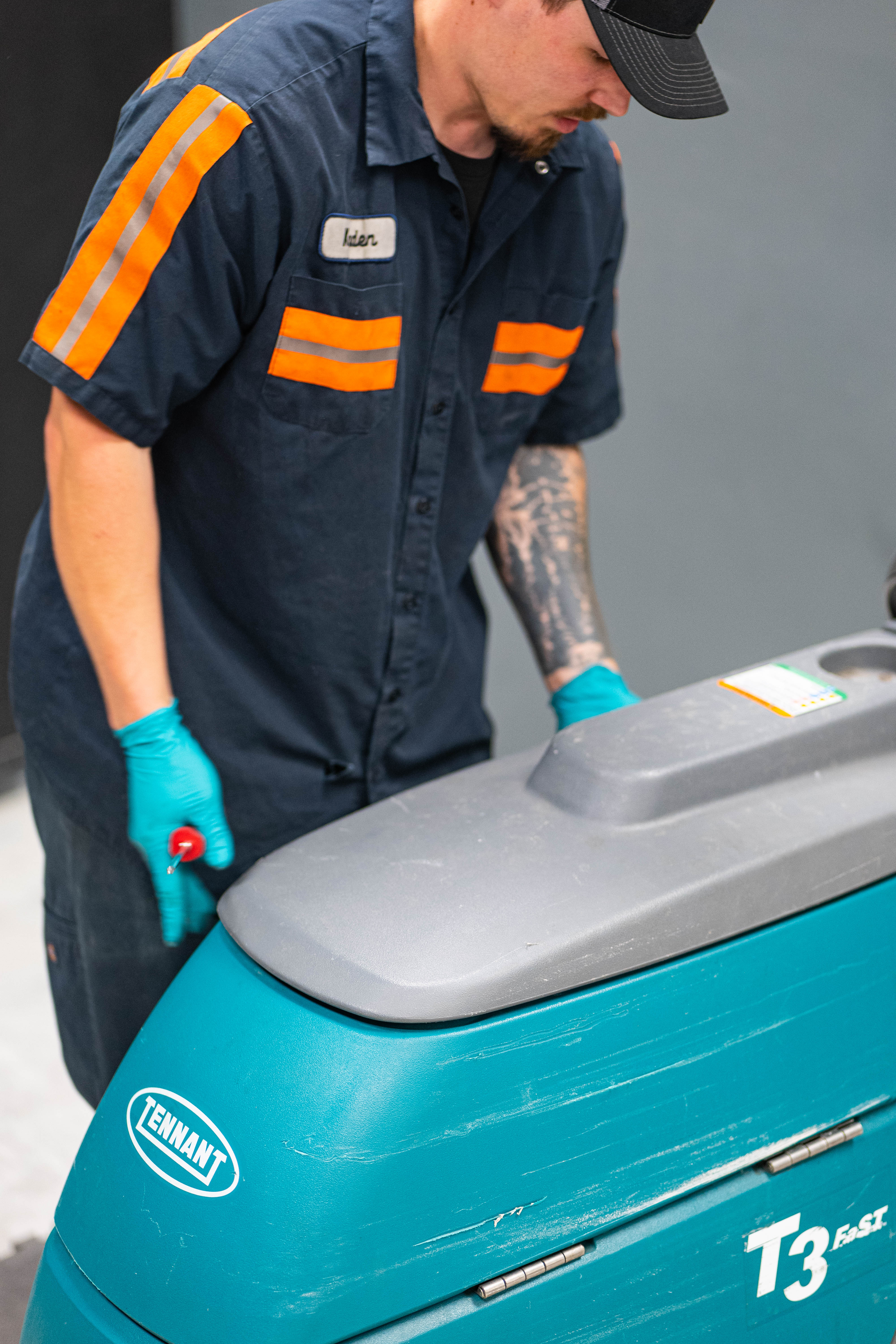 A certified WaySolutions technician prepares to service the upper control console of a teal Tennant T3 FAST walk-behind floor scrubber. Serving commercial facilities across Layton, Utah, our experts provide swift, top-to-bottom maintenance to ensure your trusted daily cleaning equipment is always safe, responsive, and ready for use.