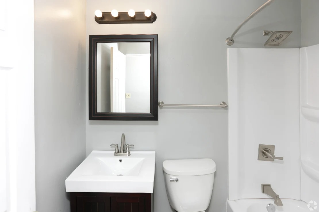 a small bathroom with a sink toilet and shower at Southern Manor Apartments, Grand Forks, North Dakota